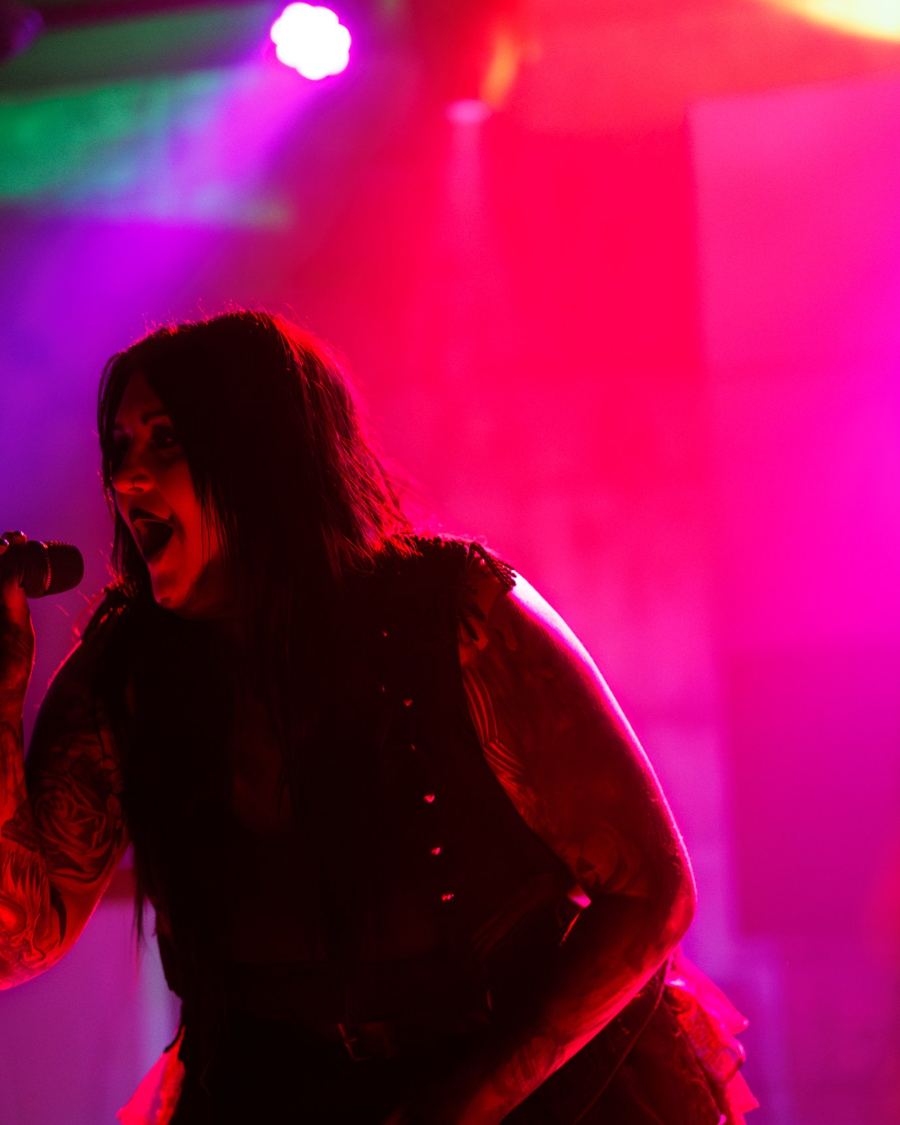 Singer performing under pink and red stage lights